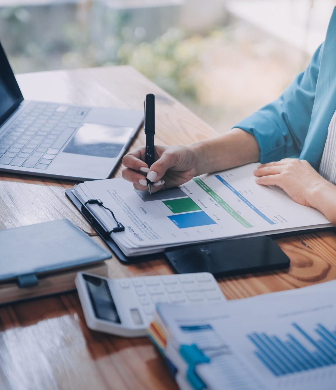 Asian Business woman using calculator and laptop for doing math finance on an office desk, tax, report, accounting, statistics, and analytical research concept